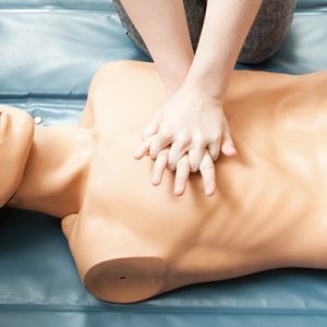 Person administering CPR on a manikin