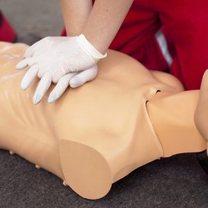 Person administering CPR on a manikin